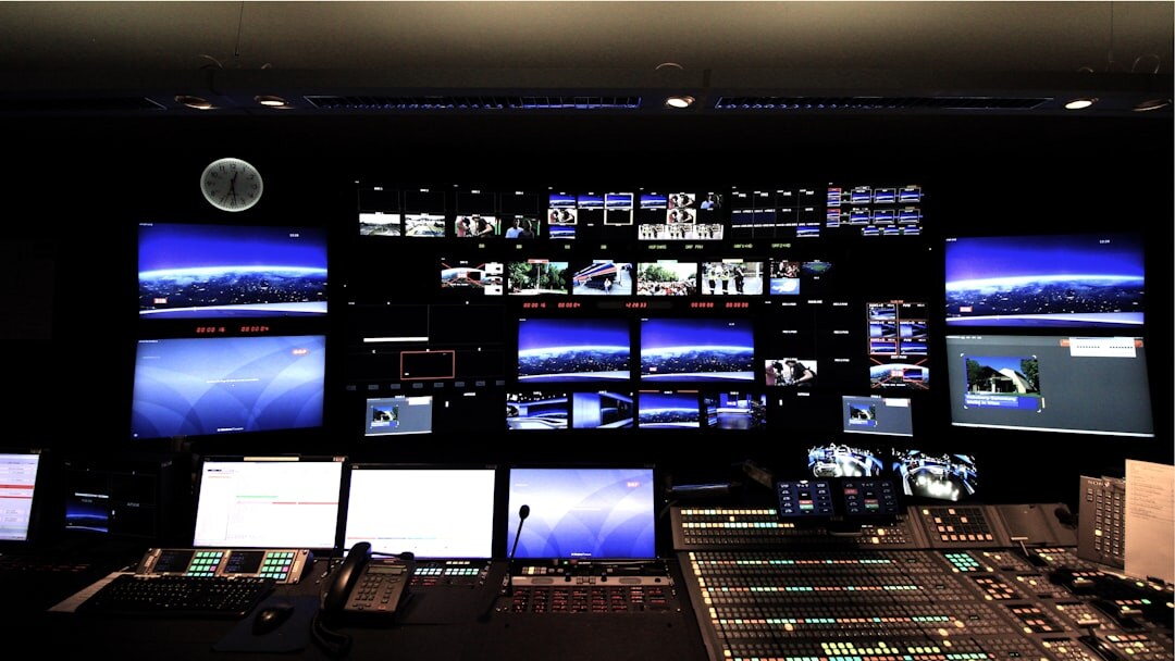 Journalist working in a modern newsroom with multiple screens
